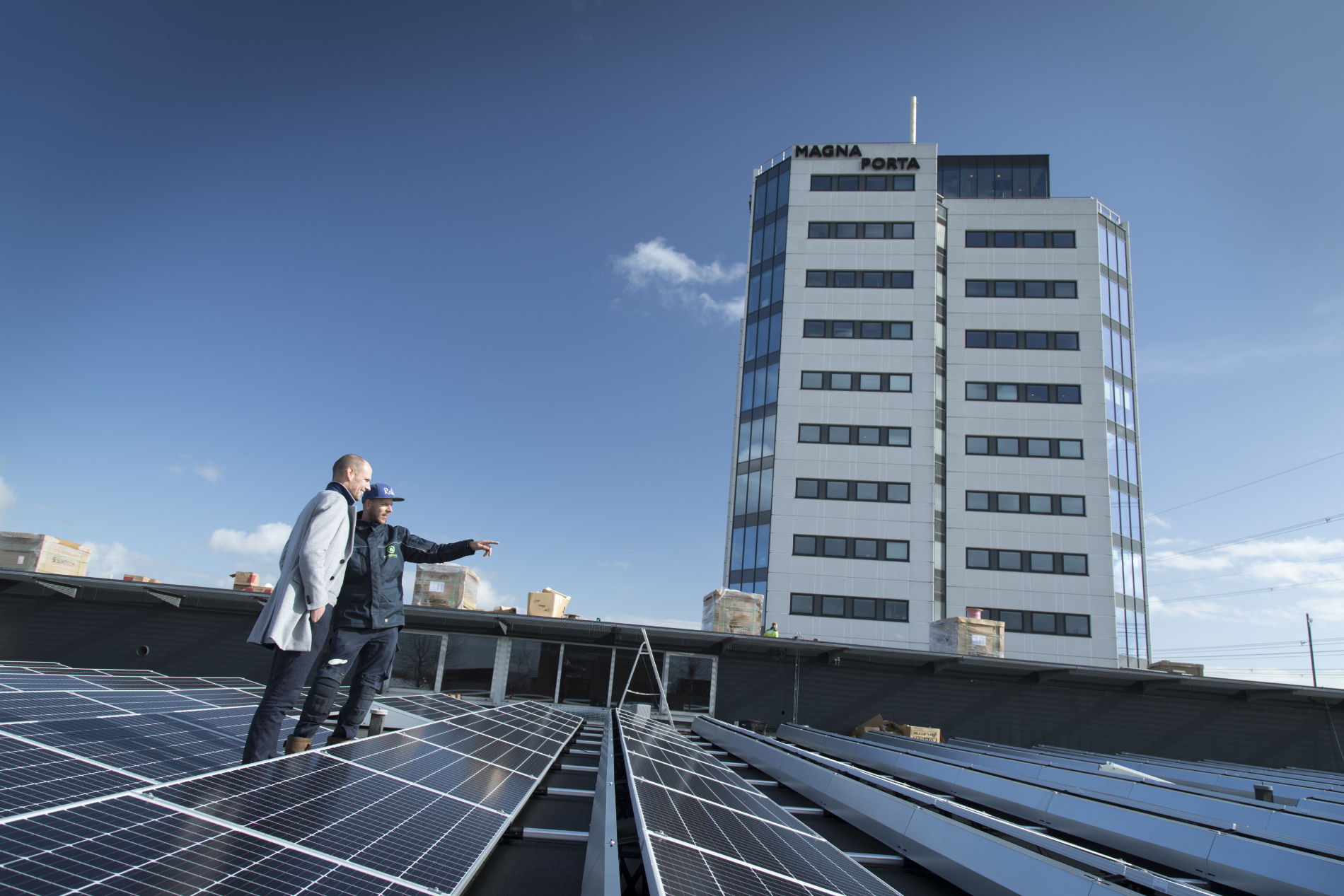 Rij Nederlandse woningen met zonnepanelen naast een kantoorgebouw